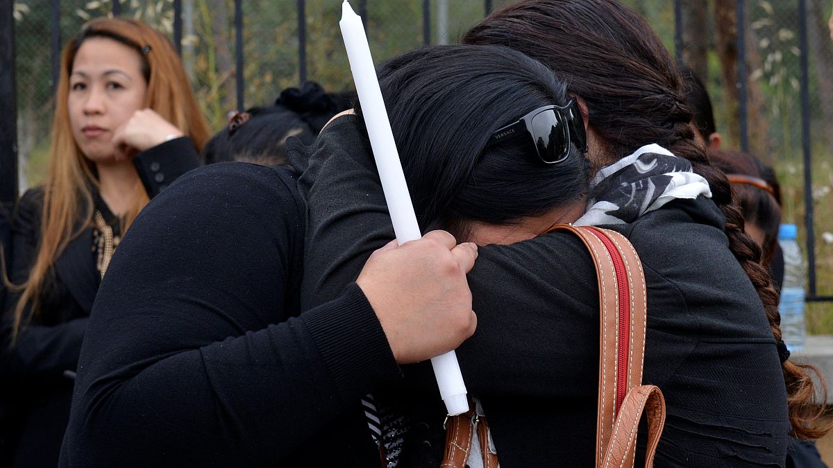 Women hug during a vigil in memory of victims of a suspected serial killer
