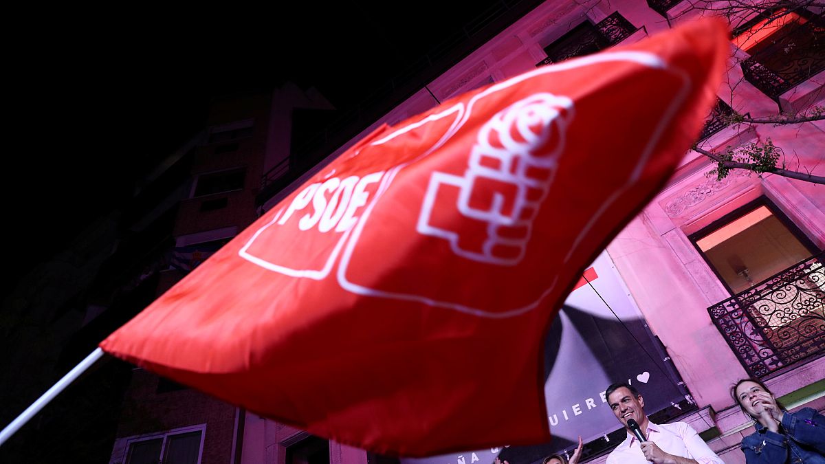 Eine Flagge der PSOE weht vor Pedro Sánchez