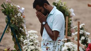 رجل يبدو متأثرا خلال مراسم جنائزية لضحايا هجمات في كنيسة في نجومبو