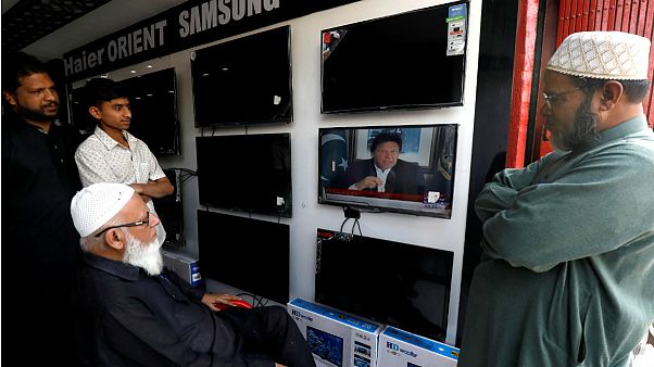 شهروندان پاکستانی در حال مشاهده عمران خان نخست وزیر این کشور شهروندان پاکستانی در حال مشاهده عمران خان نخست وزیر این کشور