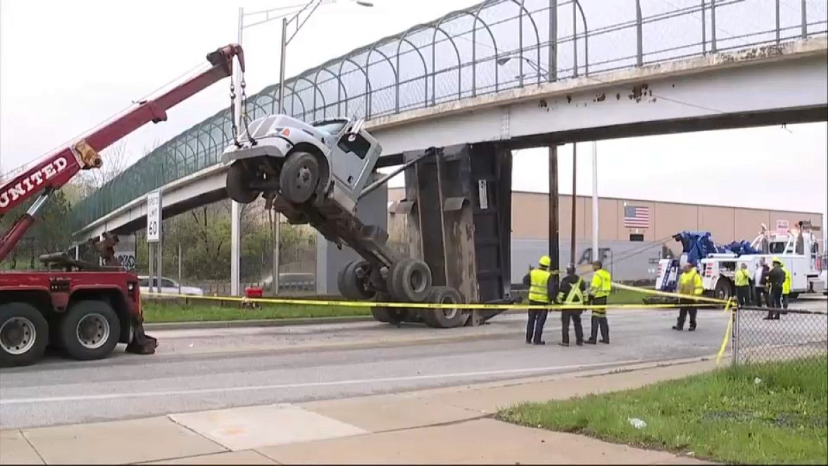شاحنة ترتفع في الهواء بعد أن علق قلابها بجسر للمشاة 