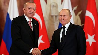 الرئيس التركي أردوغان يصافح نظيره الروسي بوتين