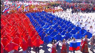 Paradeteilnehmer sind in den russischen Nationalfarben gekleidet