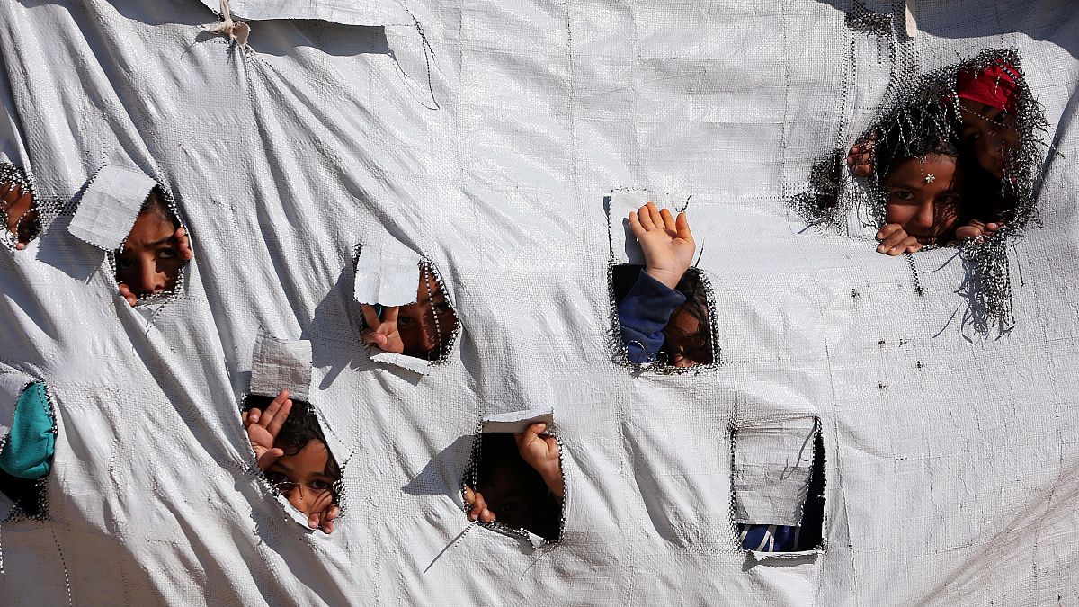 Enfants sortant leurs têtes d'une tente dans le camp d'Al-Hol