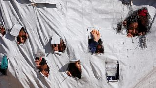 Enfants sortant leurs têtes d'une tente dans le camp d'Al-Hol