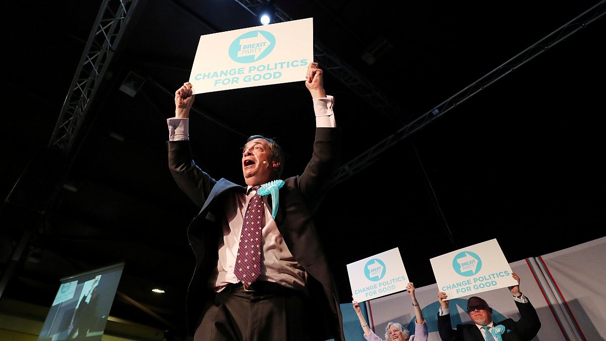 Nigel Farage hält ein Schild: "change politics for good"