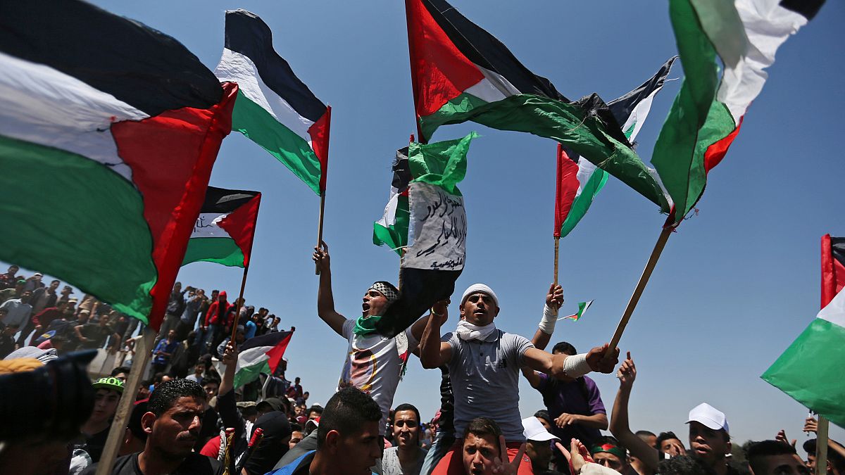 متظاهرون يحملون الأعلام الفلسطينية أثناء الاحتفال بالذكرى 71 للنكبة