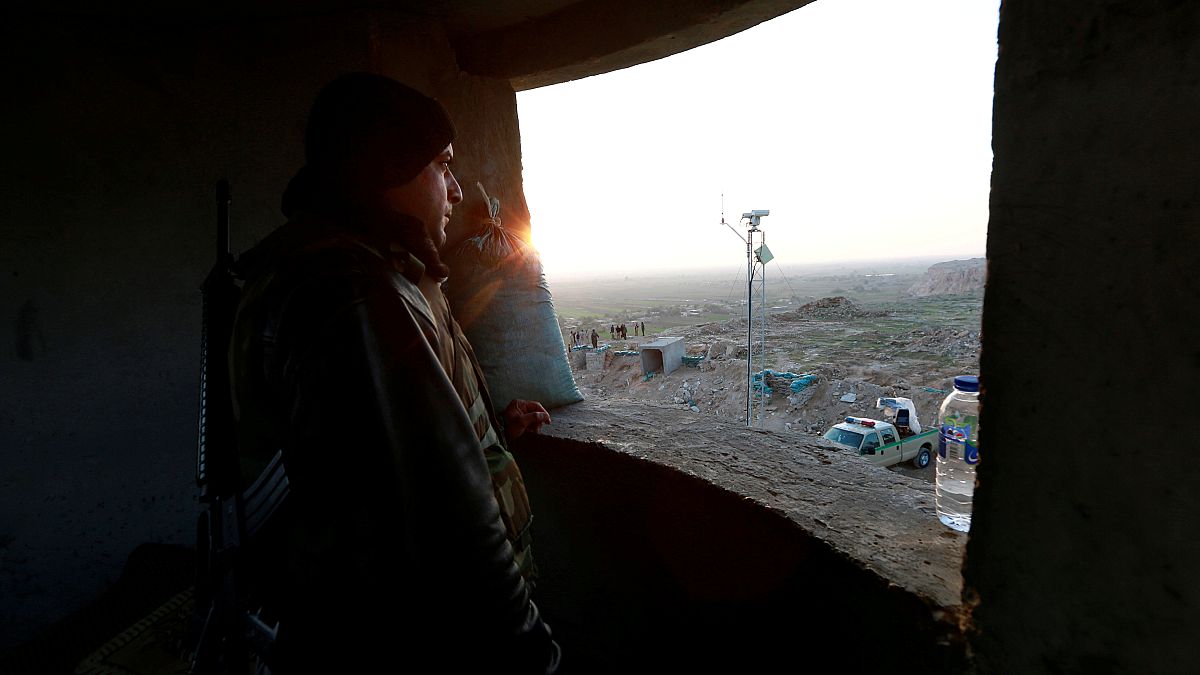 مقاتل من قوات الحشد الشعب يقف عند نقطة مراقبة حدودية في العراق