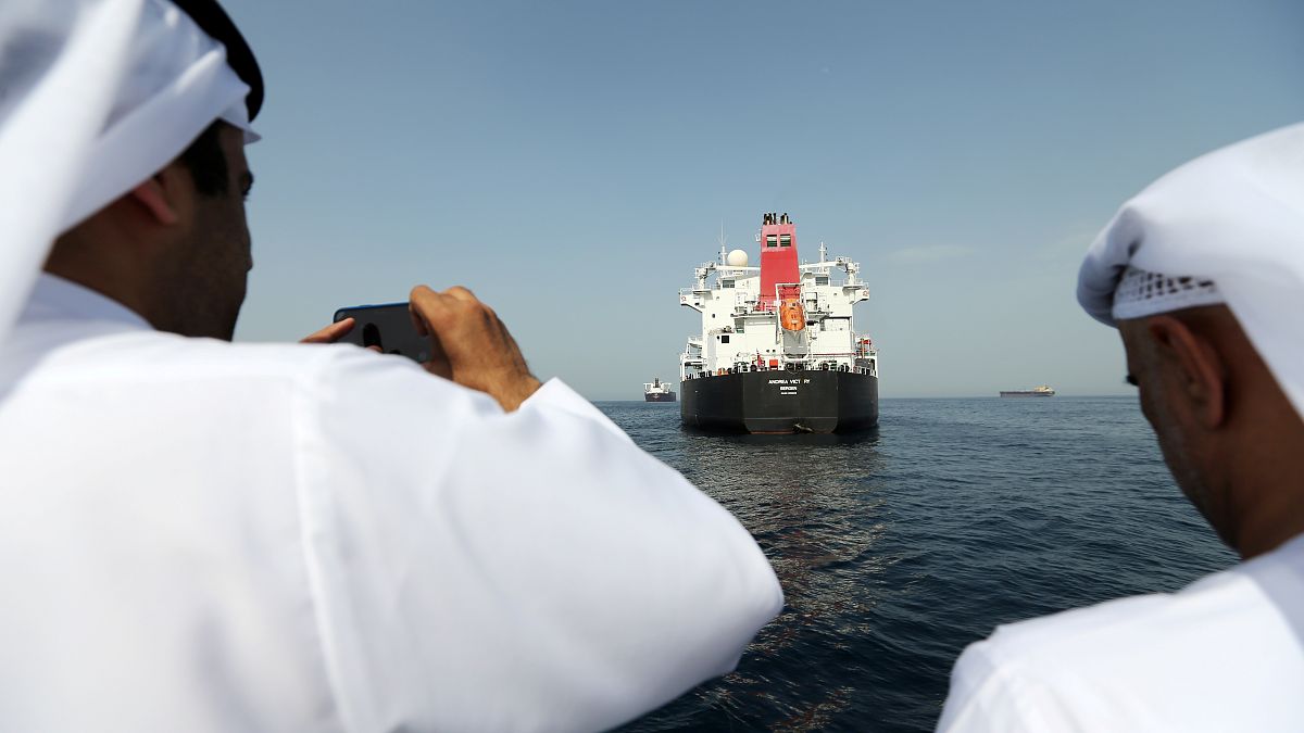 مسؤولون يلتقطون صورا لسفينة فيكتوري المتضررة في ميناء الفجيرة الإماراتي