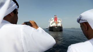 مسؤولون يلتقطون صورا لسفينة فيكتوري المتضررة في ميناء الفجيرة الإماراتي