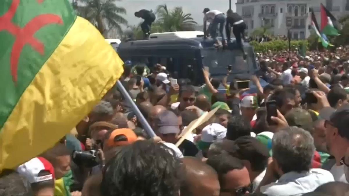 شاهد: متظاهران جزائريان يدفعان بشرطي رشهم بالغاز من أعلى عربة أمنية