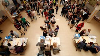 People cast their votes at a ballot station