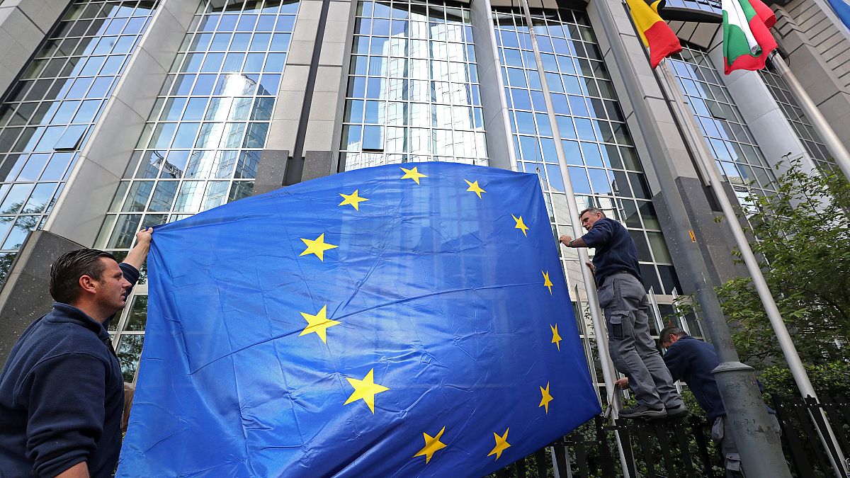 Arbeiter richten EU-Flagge am Parlament in Brüssel