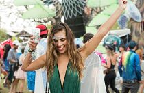Festival goer dances with drink in hand.