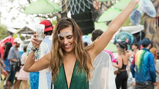 Festival goer dances with drink in hand.