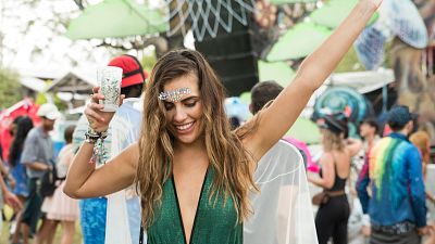 Festival goer dances with drink in hand. Festival goer dances with drink in hand.