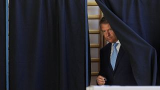 Romanian President Klaus Iohannis leaves a polling booth