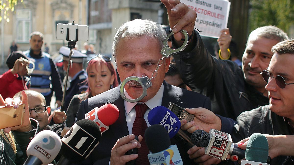 Liviu Dragnea has handcuffs waved in front of him by Romanian protesters