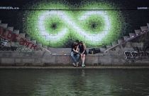Egy pár ül a Duna partján Bécsben 2017 nyarán