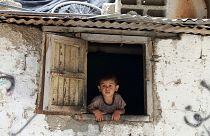 طفل فلسطيني ينظر من نافذة منزله في مخيم خان يونس جنوب غزة