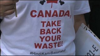 أحد المتظاهرين يرتدي تي شيرت كتب عليها "كندا خذي نفاياتك"
