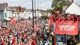 Liverpool's team bus travels past fans during the parade 