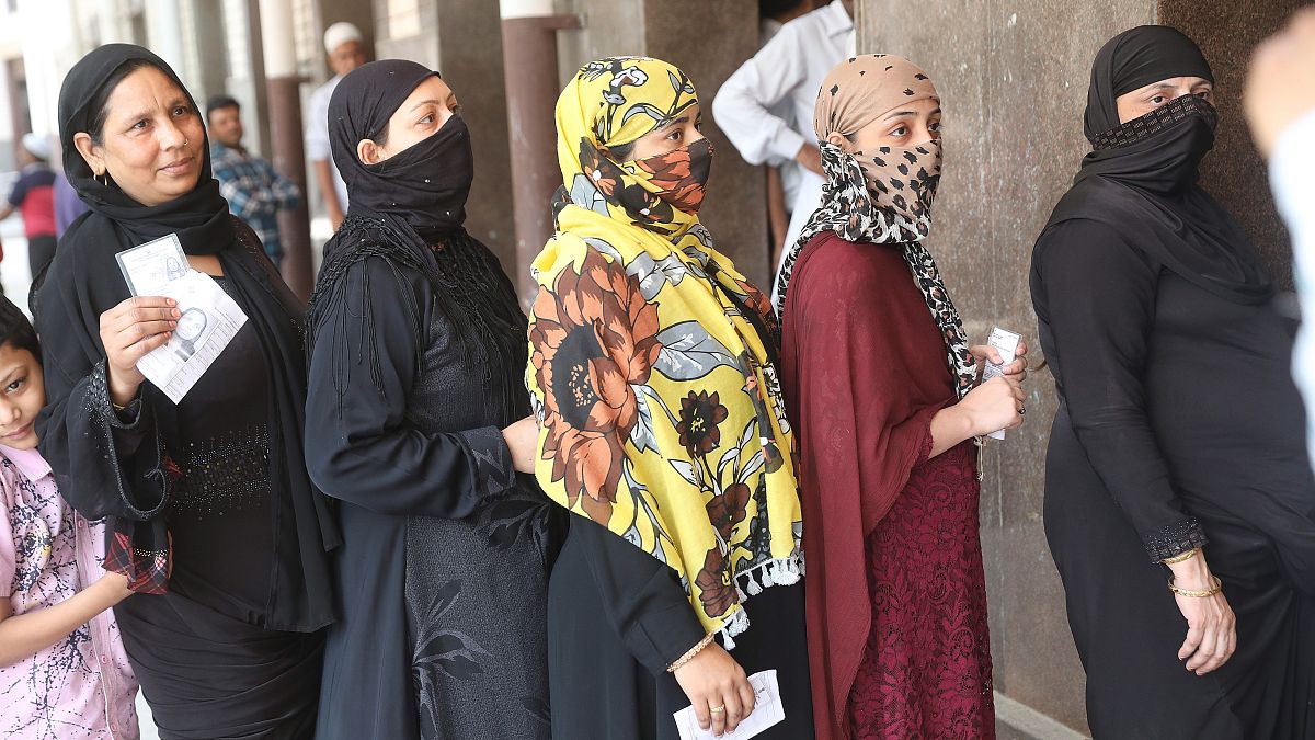 Indiai nők várakoznak egy szavazóhelyiség előtt Újdelhiben