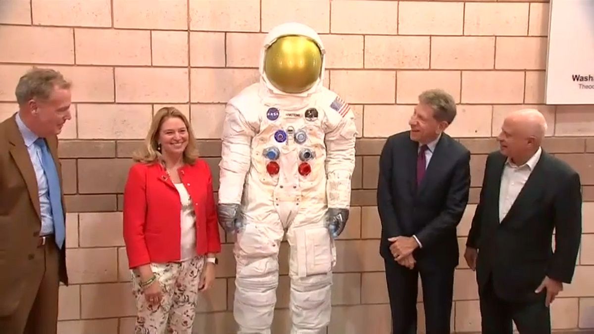 مسؤولون أميركيون بجانب مجسم بدلة رائد الفضاء نيل أرمسترونغ 