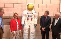 مسؤولون أميركيون بجانب مجسم بدلة رائد الفضاء نيل أرمسترونغ