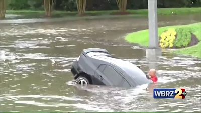 Firefighters save driver after car swept away in flash floods