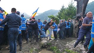 Romanian crowd push their way into a graveyard