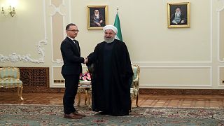 الرئيس الإيراني حسن روحاني مصافحاً وزير الخارجية الألماني