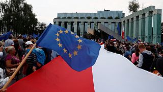 People wave European Union and Polish flags during a protest against supreme court legislation in Warsaw, Poland, July 21, 2017