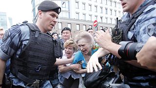 Women react as members of Russia's National Guard detain participants of a rally in support of Russian investigative journalist Ivan Golunov in Moscow