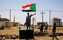 متظاهر سوداني يرفع العلم الوطني في الخرطوم يوم 5 يونيو حزيران 2019