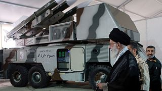 Iran's Supreme Leader Ayatollah Ali Khamenei beside a missile system
