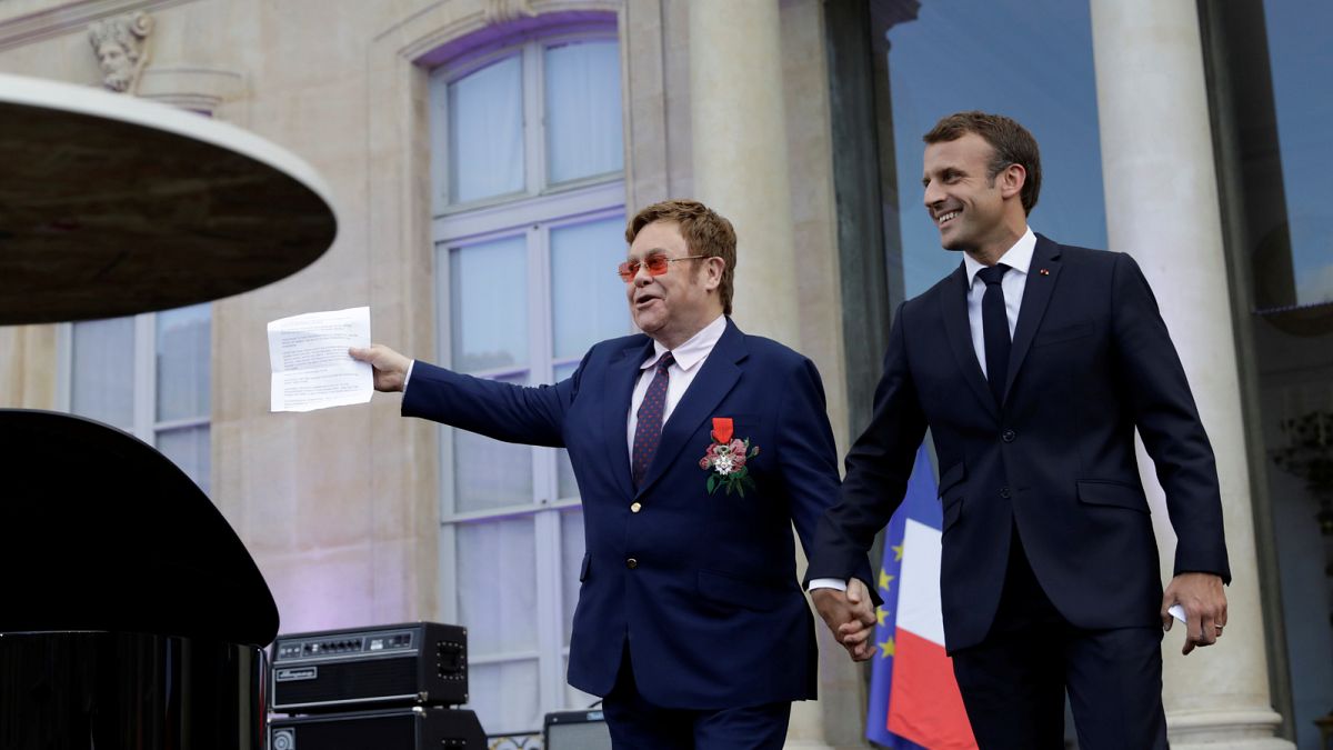 Sir Elton John és Emmanuel Macron francia elnök kézenfogva az Élysée-palota előtt
