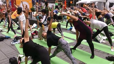 Rain doesn't stop yogis from celebrating the summer solstice in Times Square