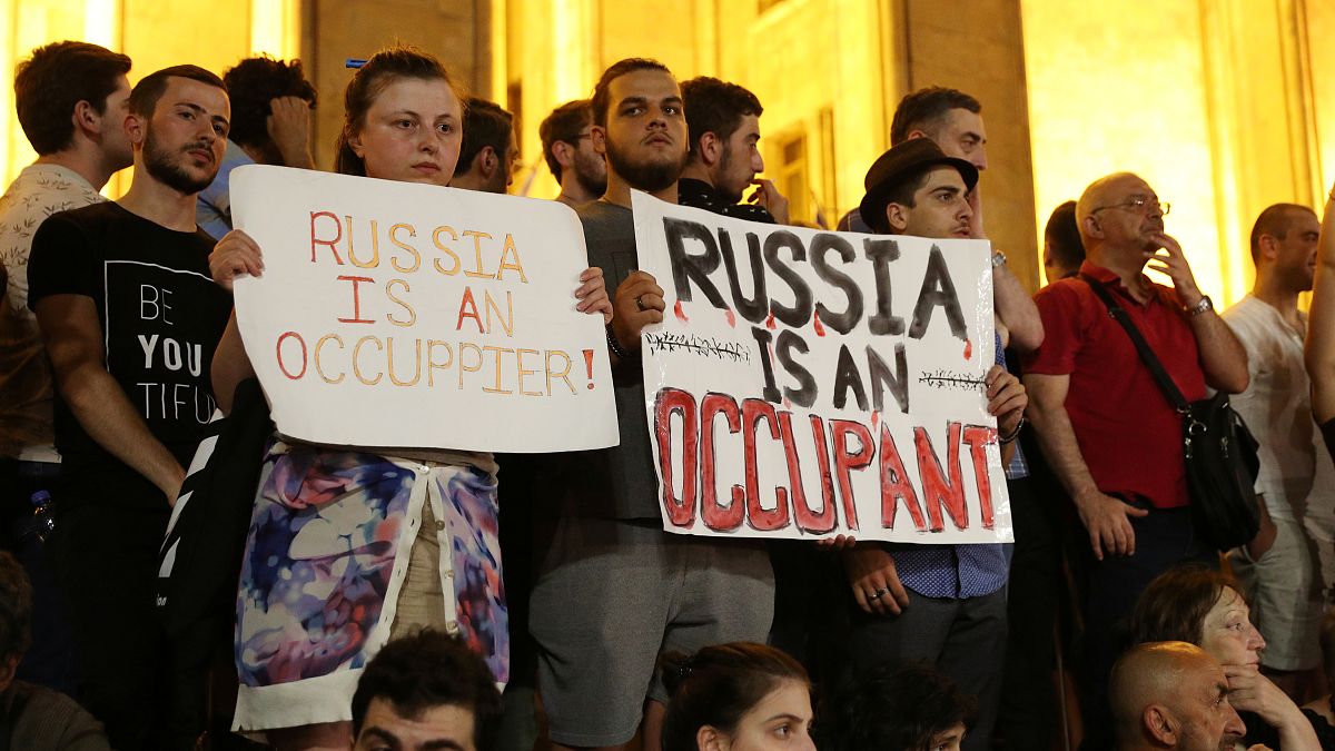 Protestocular "Rusya bir işgalci" yazan pankartlar taşıdı