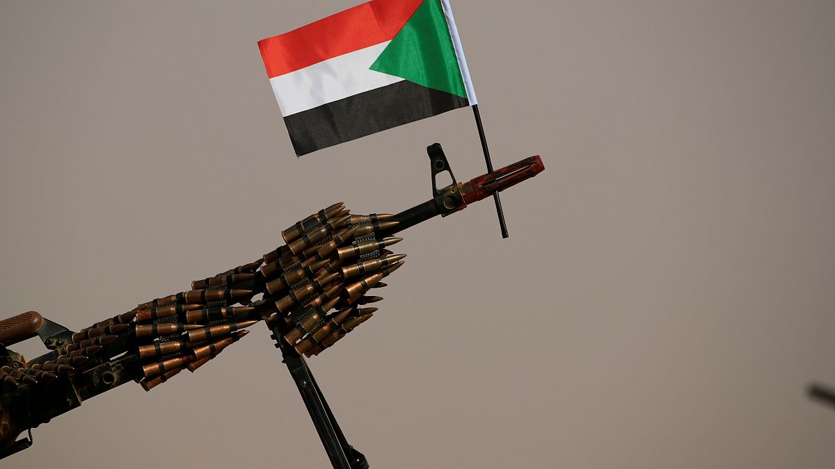علم السودان مرفوع على فوهة بندقية آلية لقوات الدعم السريع "الجنجويد". حزيران/2019