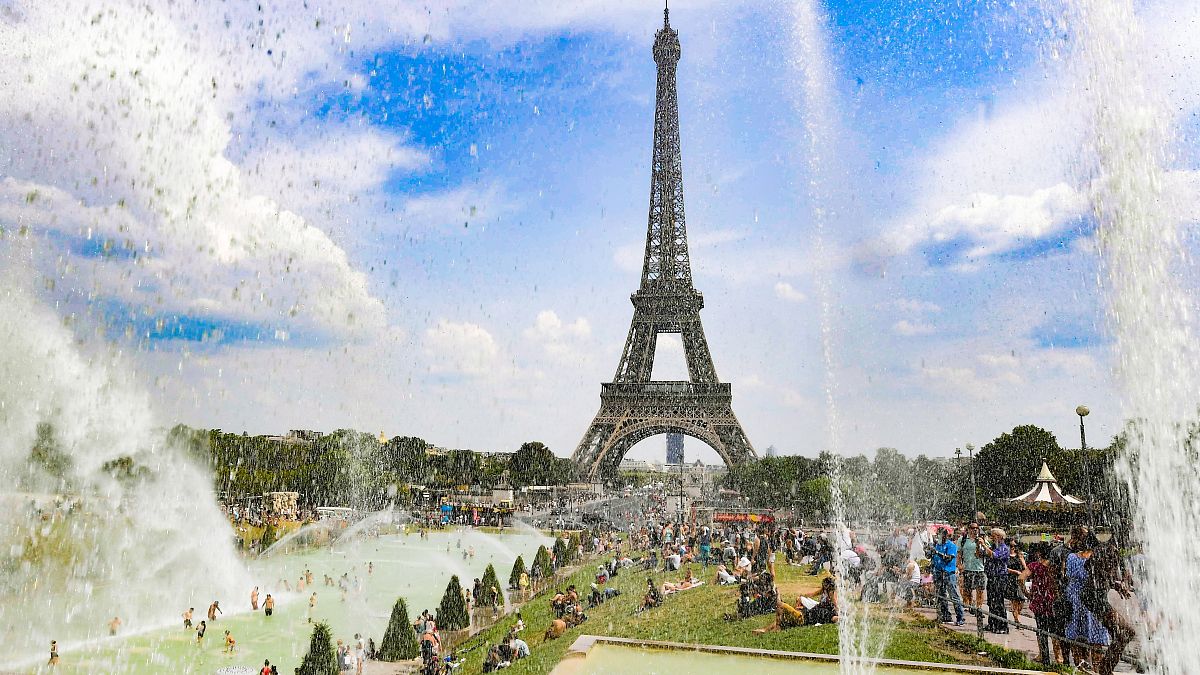 Az emberek a párizsi Trocadero szökőkútjainak vizében hűsölnek 2018. augusztus 7-én