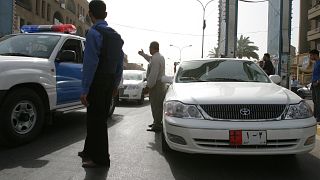 رجل أمن عراقي يحرس سيارة تابعة لسفارة البحرين في بغداد بعد إطلاق النار على دبلوماسي بحريني. تموز/2005