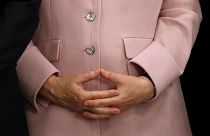 المستشارة الألمانية أنجيلا ميركل تمسك بيديها خلال مؤتمر صحفي في قمة مجموعة العشرين في أوساكا باليابان