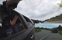 شاهد: سائق يأبى التوقف ويجر شرطيا أمريكيا بسيارته عشرات الأمتار