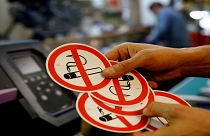 موظف يُظهر لافتات "ممنوع التدخين" في ورشة الطباعة في فيينا/ النمسا 2018