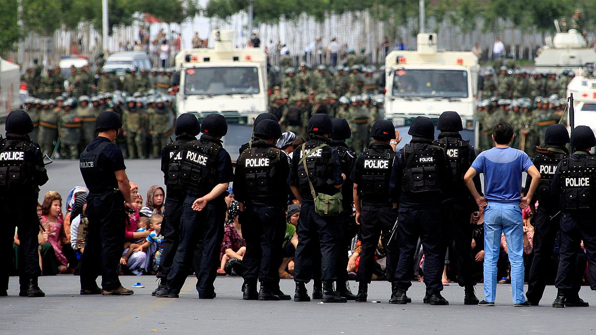 Doğu Türkistan'ın başkenti Urumçi'de Çinli güvenik güçlerince çembere alınan Uygur kadınlar ve çocukları