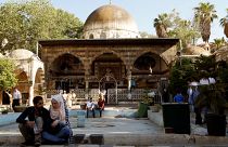 People sit near the Ottoman-era Tekkiye Suleimaniye mosque complex in Damascus, Syria