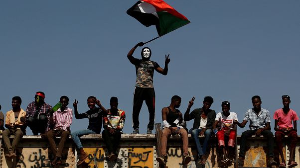 FILE PHOTO: A Sudanese protester wearing a Guy Fawkes mask waves a national flag outside the Defense Ministry compound in Khartoum FILE PHOTO: A Sudanese protester wearing a Guy Fawkes mask waves a national flag outside the Defense Ministry compound in Khartoum