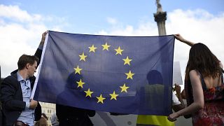 شاب وشابة يحملان علم الاتحاد الأوروبي في وسط العاصمة البريطانية لندن. حزيران 2016