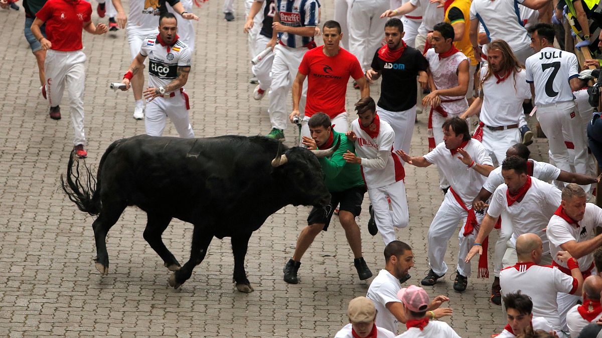 Revellers attempt to dodge a bull during the first running of the bulls at the San Fermin festival in Pamplona, Spain, July 7, 2019.